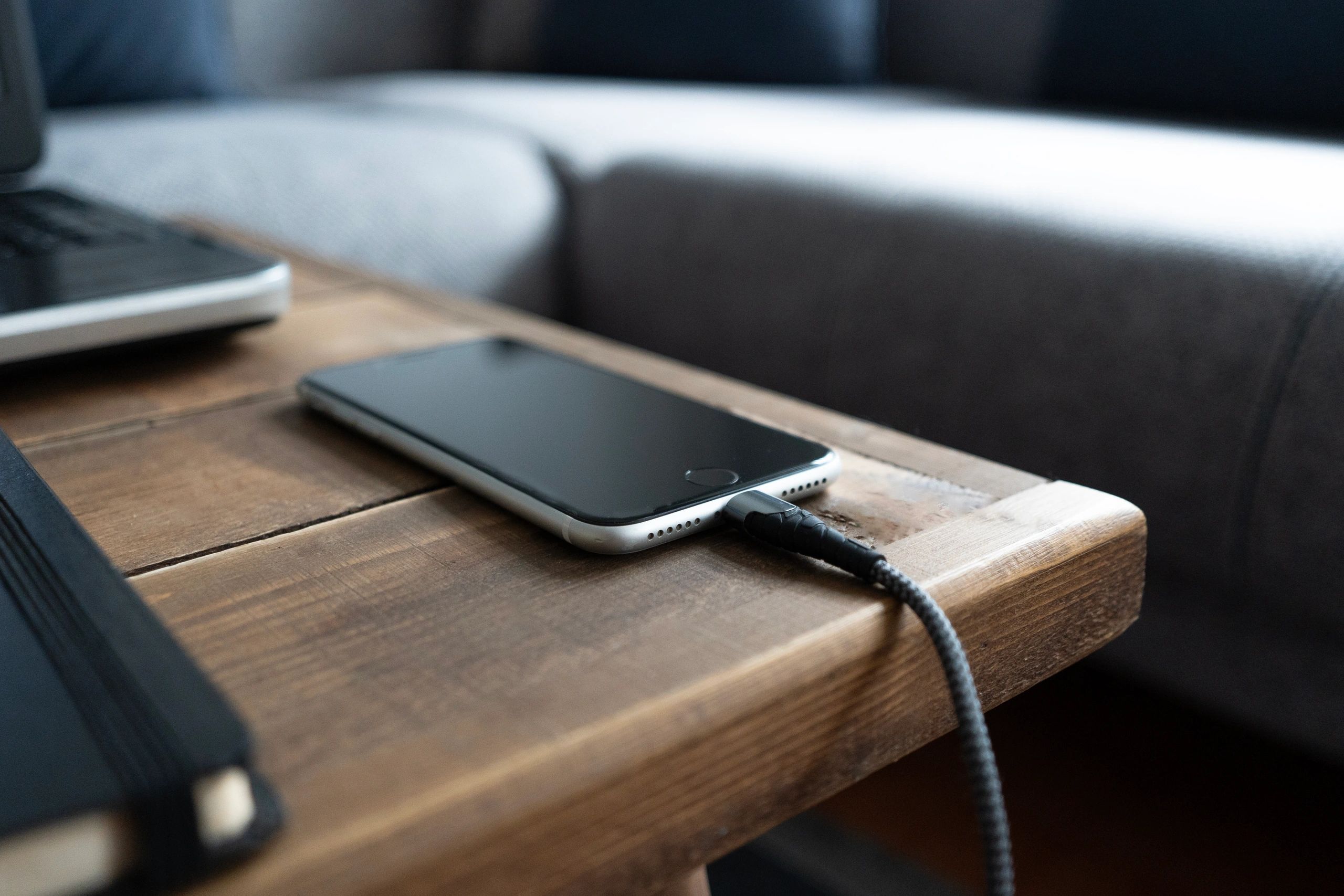 Phone connected to a compact wall charger at home